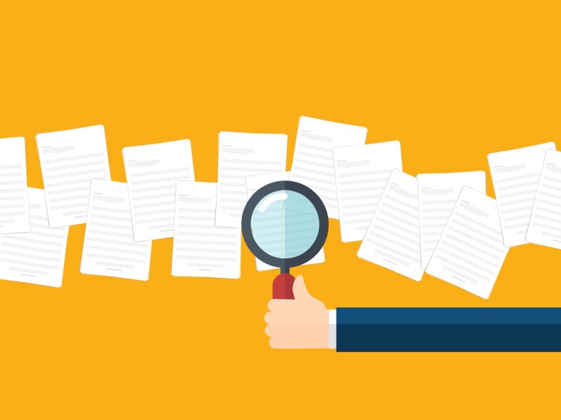 An illustration shows a hand holding a magnifying glass over scattered sheets of paper against an orange background.