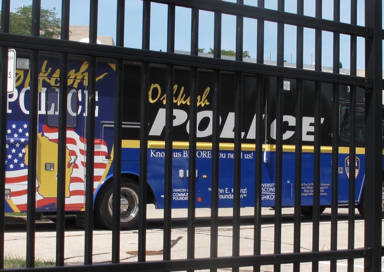 Oshkosh Police vehicle behind a fence